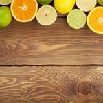 Citrus fruits. Oranges, limes and lemons. Over wooden table back