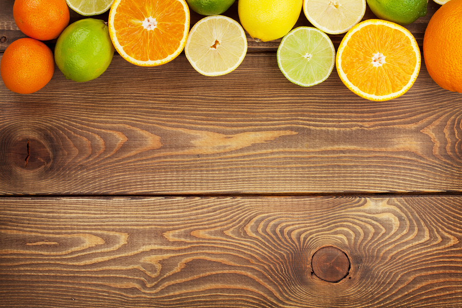 Citrus fruits. Oranges, limes and lemons. Over wooden table back